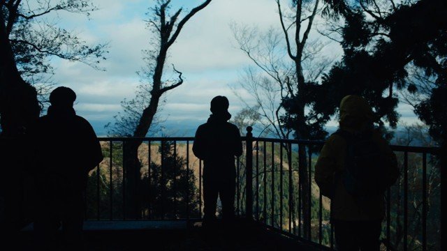 Three people sharing their attention toward a mountain horizon