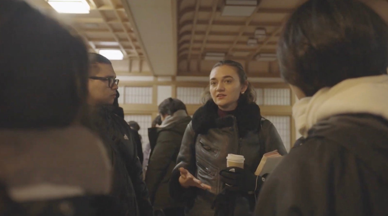 Larissa May speaking with others over coffee.